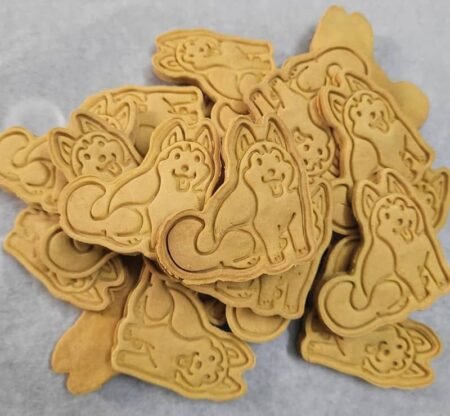 Pumpkin pet biscuits shaped like huskies, with detailed embossed designs and a golden-brown baked finish.