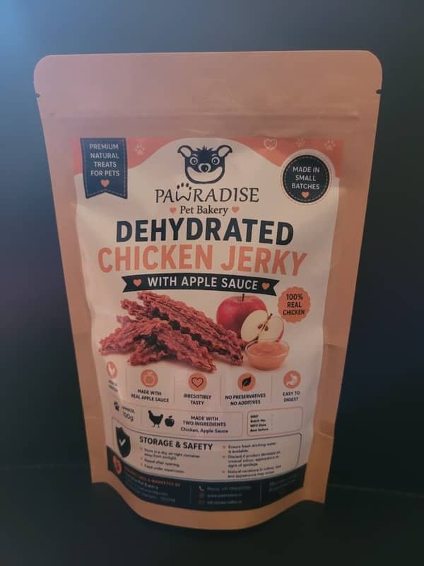 Back view of Pawradise Pet Bakery dehydrated chicken jerky in a brown stand-up pouch with a transparent window showing the chicken treats inside