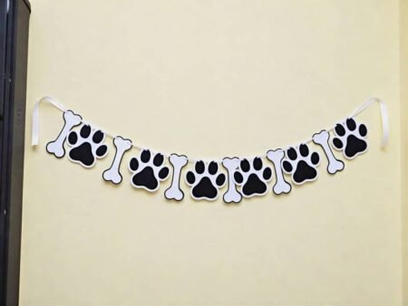 Black-and-white Paw & bone pet celebration banner featuring alternating paw prints and bone-shaped decorations strung on a white ribbon.